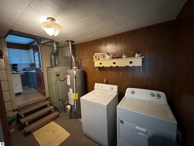 laundry room with gas water heater, wooden walls, carpet flooring, and washer and dryer