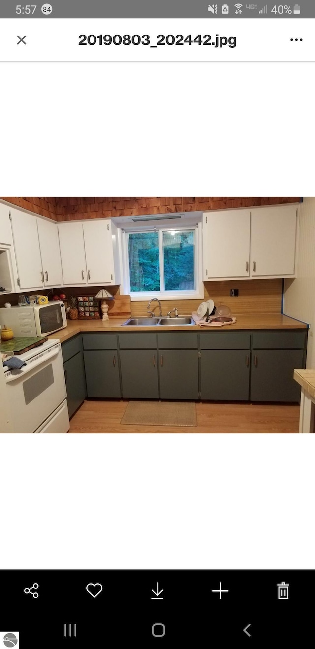 kitchen featuring white range oven, white cabinetry, sink, and gray cabinets