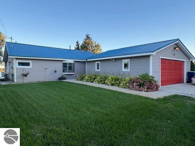 ranch-style home featuring an outdoor structure, a garage, and a front yard