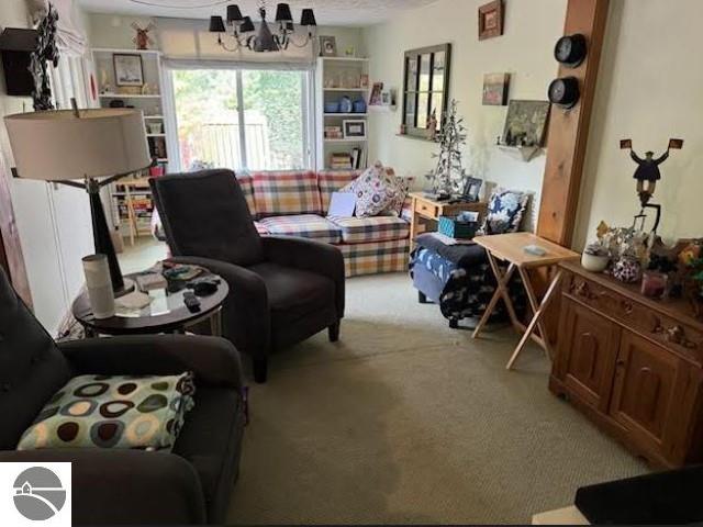 living room with light carpet and a notable chandelier