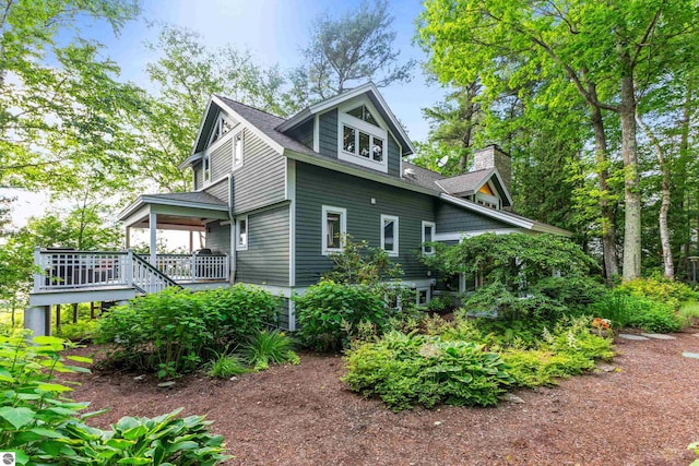 view of side of property featuring a wooden deck