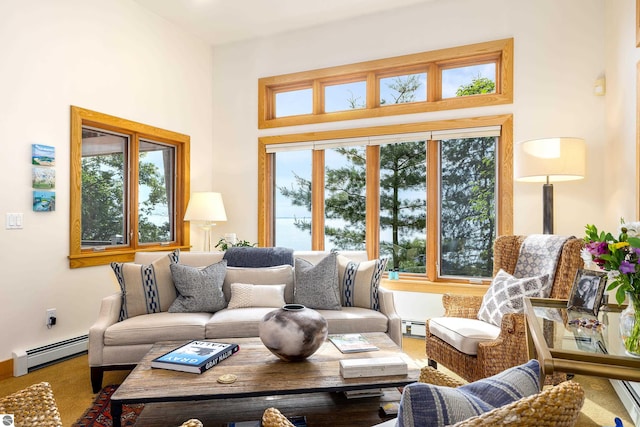 carpeted living room with plenty of natural light, a high ceiling, and a baseboard heating unit