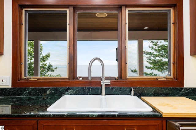 kitchen featuring dark stone counters and sink