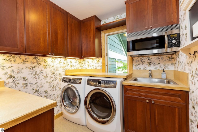 laundry area with cabinets, sink, and washing machine and dryer