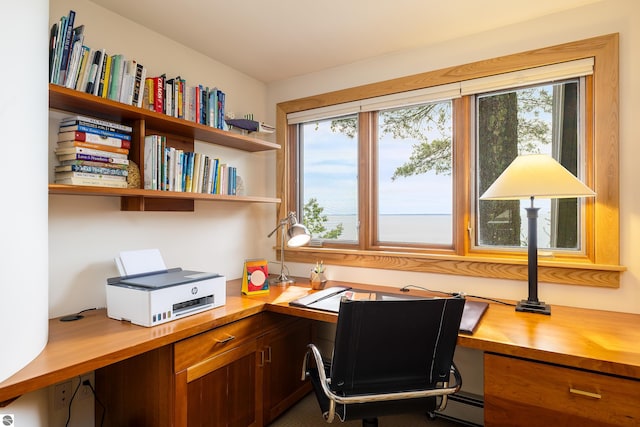 office featuring baseboard heating, built in desk, and a healthy amount of sunlight