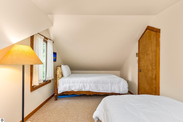 bedroom featuring carpet and vaulted ceiling