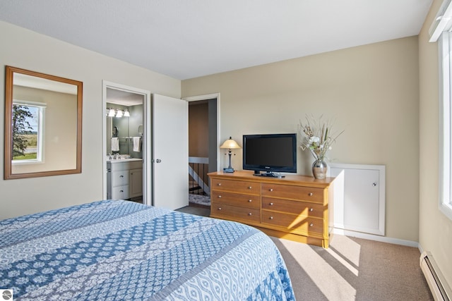 bedroom featuring carpet floors, a baseboard heating unit, and ensuite bathroom