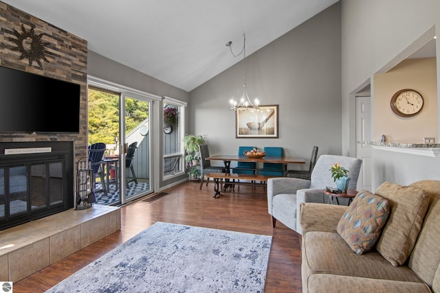 living room with dark hardwood / wood-style floors, a chandelier, high vaulted ceiling, and a tile fireplace