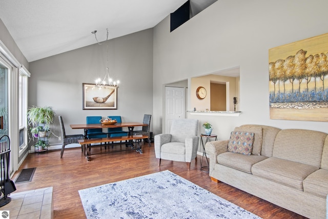 living room with an inviting chandelier, dark wood-type flooring, and high vaulted ceiling