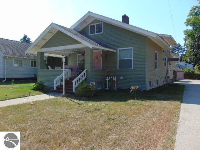 view of front of house with a front yard and a porch