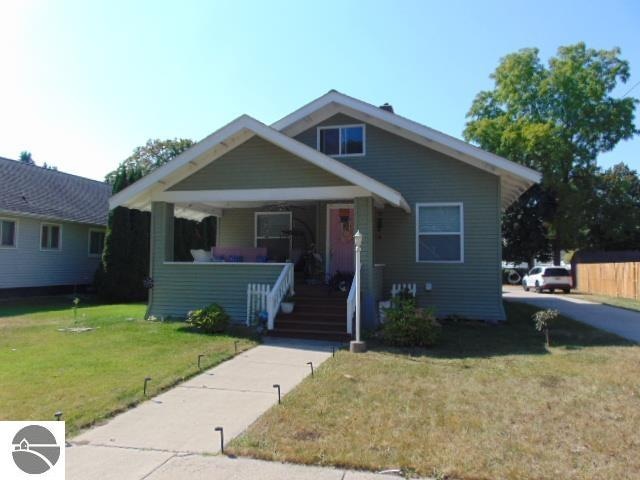 bungalow featuring a front lawn and covered porch