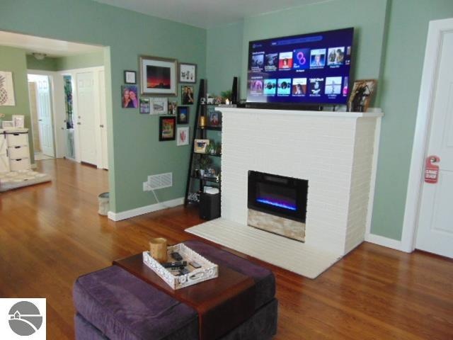 living room with a fireplace and dark hardwood / wood-style flooring