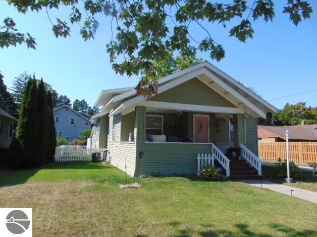 bungalow with a front lawn and a porch