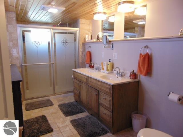 bathroom with wooden ceiling, vanity, toilet, and an enclosed shower