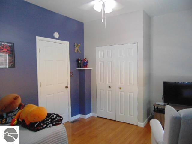 bedroom with ceiling fan, a closet, and hardwood / wood-style floors