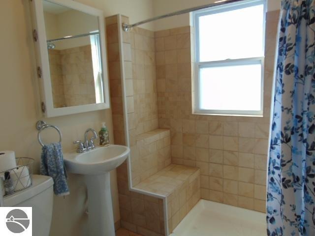 bathroom with toilet and curtained shower