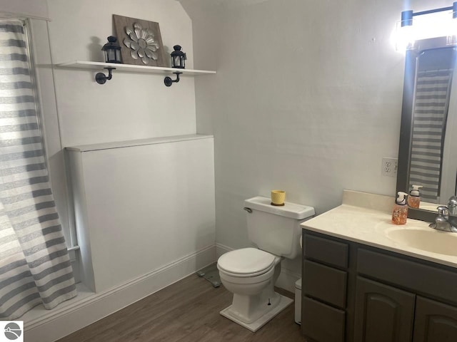 bathroom with vanity, hardwood / wood-style floors, toilet, and curtained shower