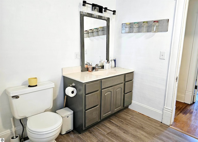 bathroom featuring wood-type flooring, vanity, and toilet