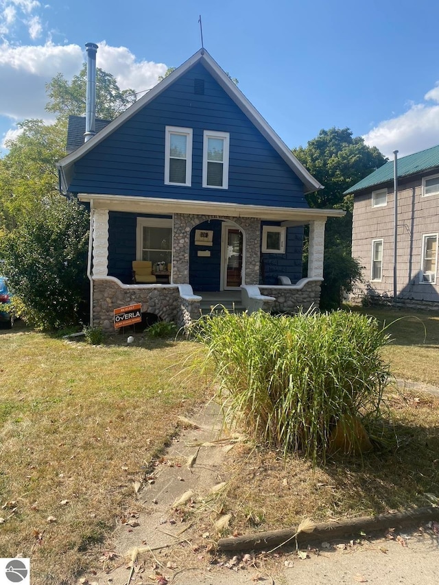 view of front of property featuring covered porch and a front yard