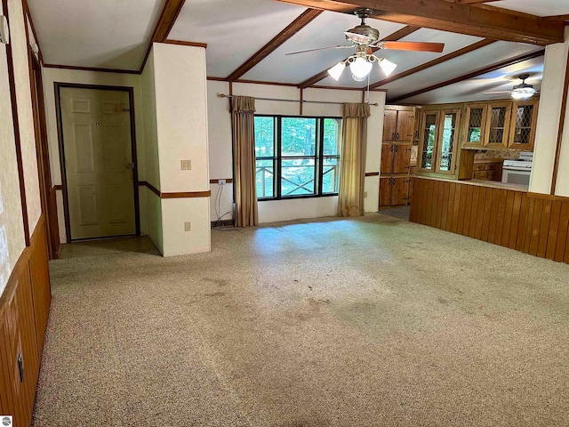 unfurnished living room featuring vaulted ceiling with beams, carpet flooring, and ceiling fan