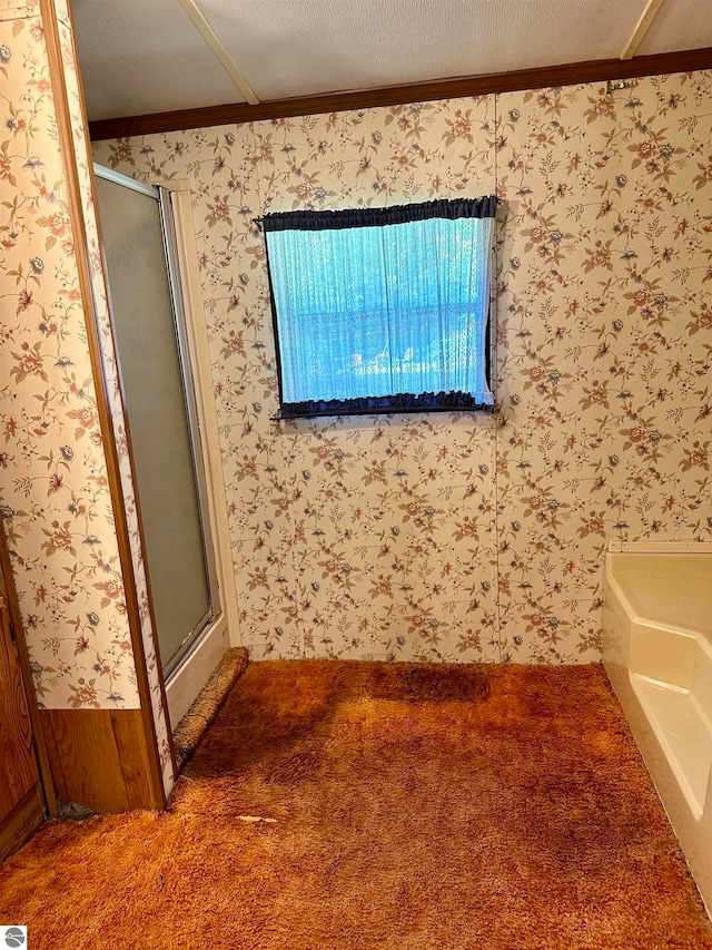 bathroom featuring a textured ceiling, ornamental molding, and plus walk in shower