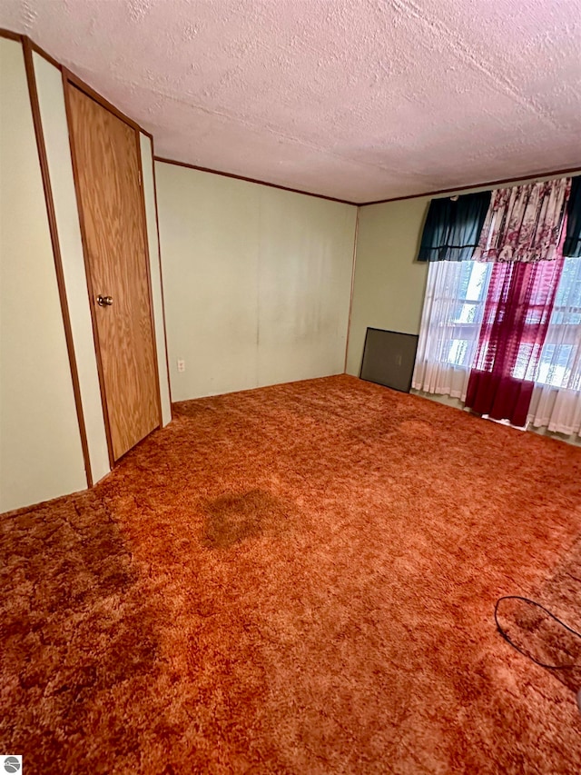 unfurnished bedroom featuring a textured ceiling and carpet flooring