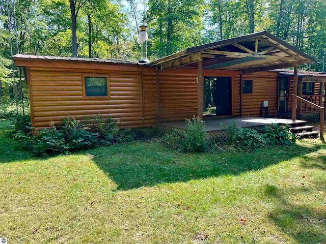 cabin featuring a front yard and a wooden deck