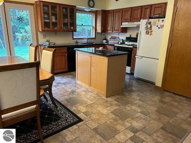 kitchen with white appliances, a kitchen island, and sink