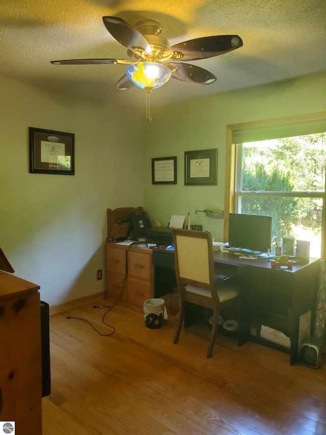 office area with ceiling fan, hardwood / wood-style flooring, and a textured ceiling