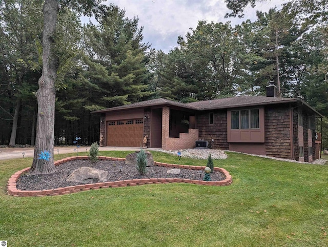 ranch-style house featuring a garage and a front lawn