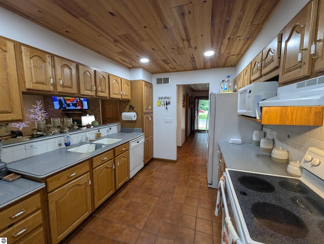 kitchen featuring decorative backsplash, dark tile patterned flooring, white appliances, and sink