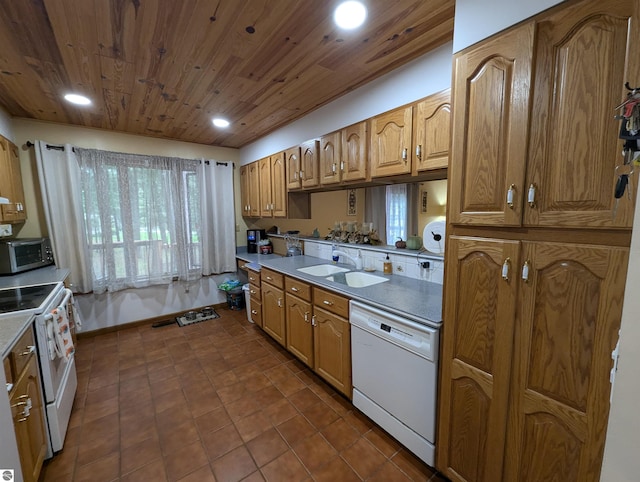 kitchen featuring wood ceiling, white appliances, dark tile patterned floors, and sink