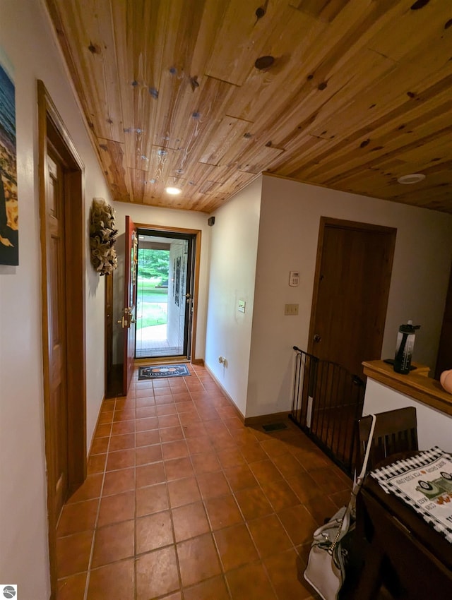 hallway featuring wood ceiling and tile patterned floors