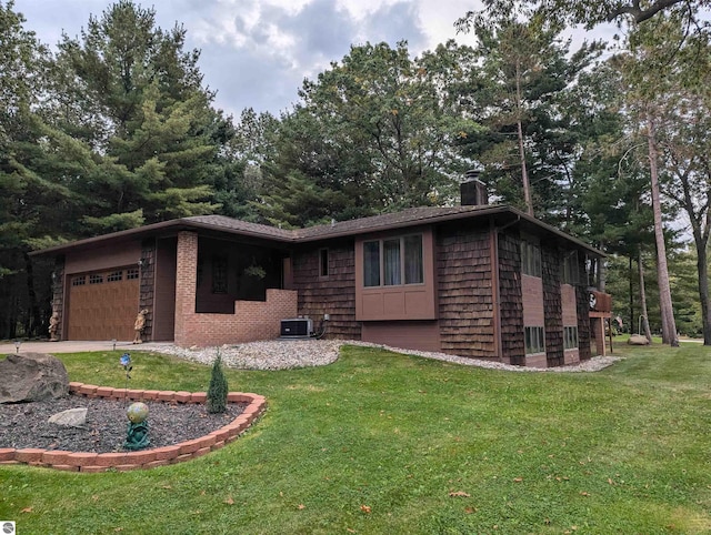 ranch-style house with cooling unit, a garage, and a front lawn