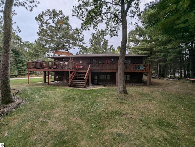 rear view of house with a lawn and a wooden deck