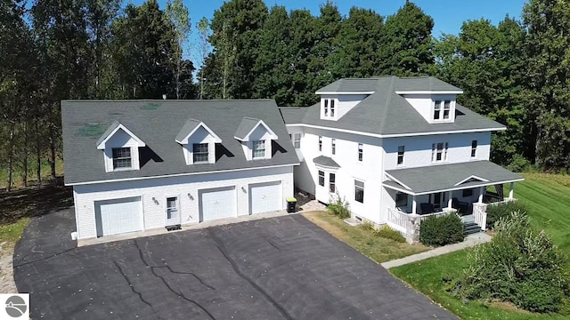 view of front of property with a front lawn, a porch, and a garage