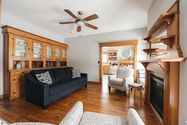 living room featuring ceiling fan and dark hardwood / wood-style flooring