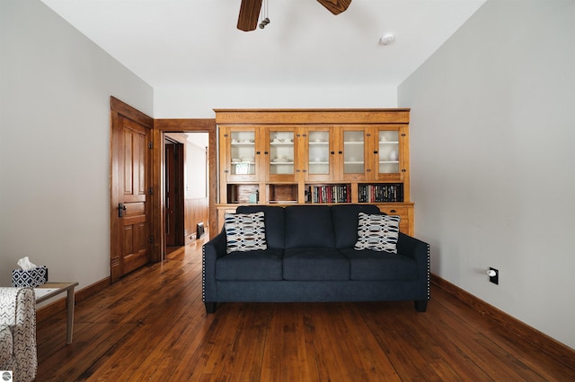 living room with dark hardwood / wood-style flooring and ceiling fan