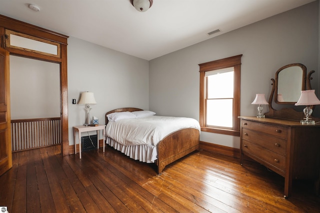 bedroom with dark wood-type flooring