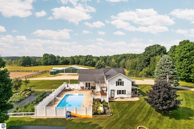 rear view of house featuring a lawn, a patio, and a fenced in pool