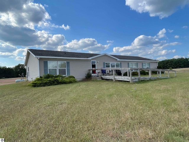 view of front of home featuring a front yard and a wooden deck