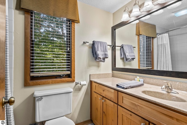 bathroom featuring a shower with curtain, a textured ceiling, vanity, and toilet