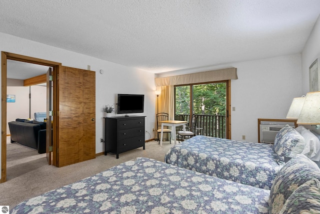 bedroom with a textured ceiling, light colored carpet, access to exterior, and a wall mounted air conditioner