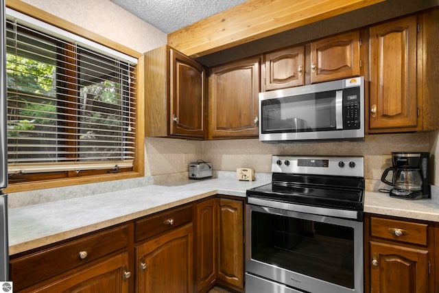 kitchen with stainless steel appliances, a textured ceiling, and tasteful backsplash