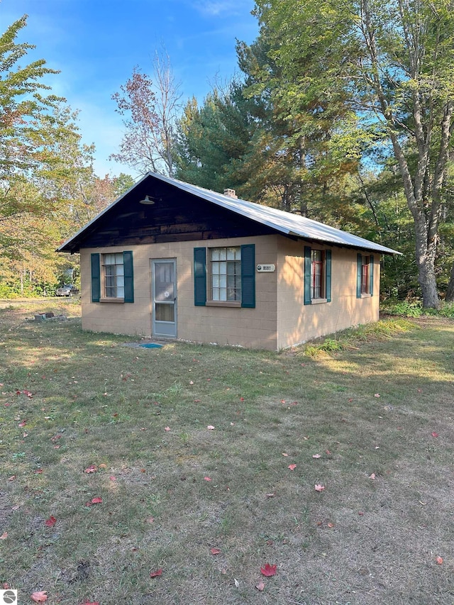 view of front of home with a front lawn and concrete block siding