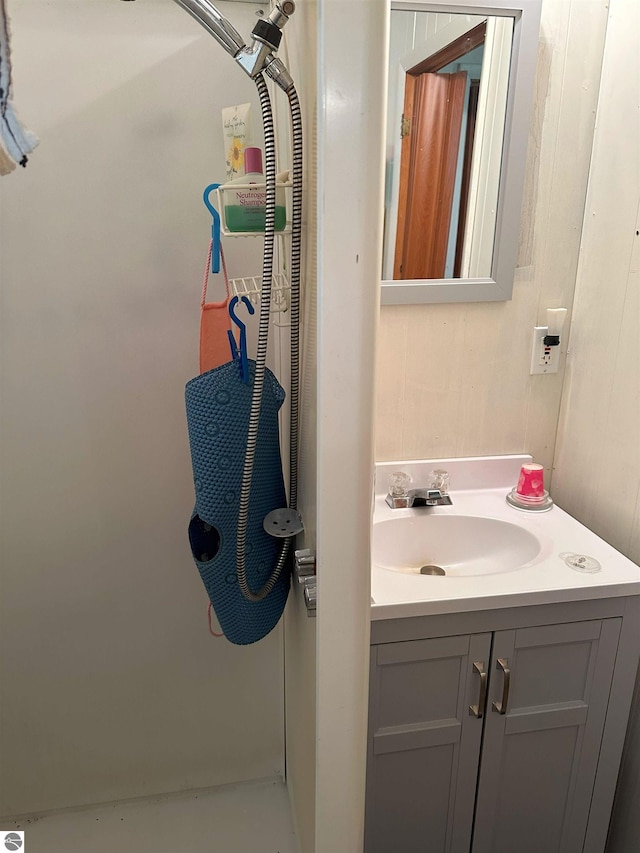 bathroom featuring walk in shower and vanity