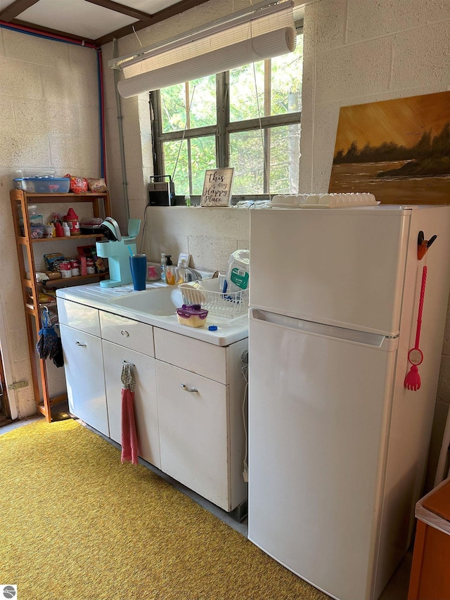 kitchen with carpet flooring, white cabinets, and white fridge