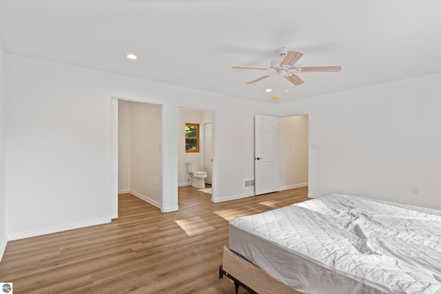 bedroom with ensuite bath, ceiling fan, and hardwood / wood-style flooring