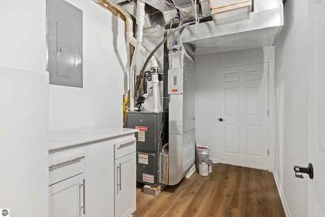 utility room featuring electric panel and heating unit