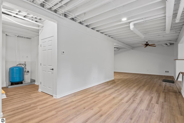 basement with light hardwood / wood-style floors and ceiling fan